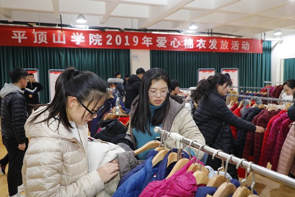 本报讯12月18日下午,学校在体育训练馆举行2019年爱心棉衣发放活动。校党委书记王文鹏、副校长程永华及学生处、各二级学院党总支负责同志、辅导员老师与受到资助的同学们共同参加了活动。图为同学们兴高采烈地讨论选择衣服的款式、颜色等,王文鹏走到学生身边,与同学们亲切交谈,了解大家在校学习、生活情况,并把选好的棉衣包装好后交到学生手中。(王亚珂 陈留彪/文 陈留彪/图)