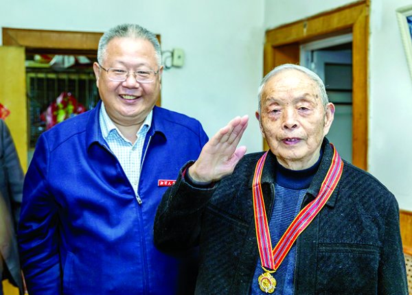 ! 校党委书记黄云清为刘爱德、胡光伦佩带“中国人民志愿军抗美援朝出国作战70周年”纪念章。 （戴飞军/摄）