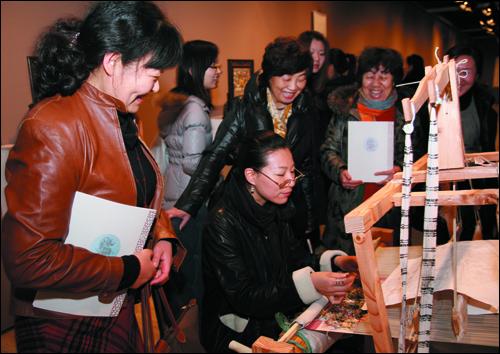 女教职工们一同观看“国家级非物质文化遗产——苏州缂丝、核雕作品展”