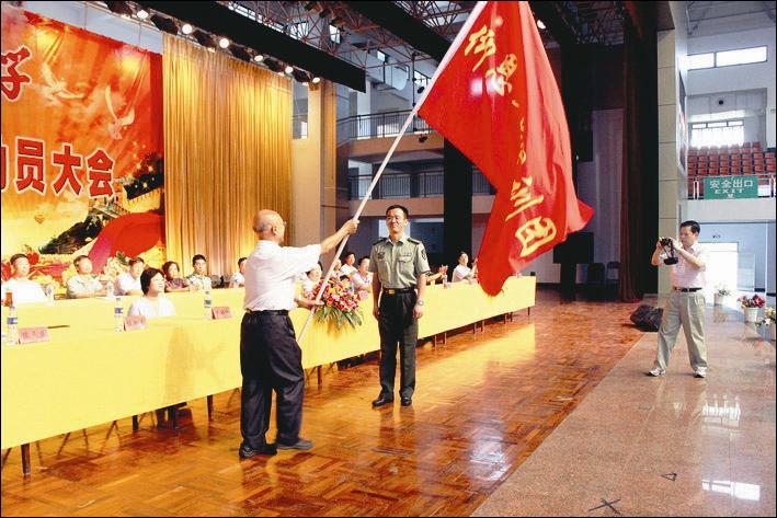 校长官鸣向泉州地区高校军训团团长陈天庆授“仰恩大学军训团”旗  胡静/摄