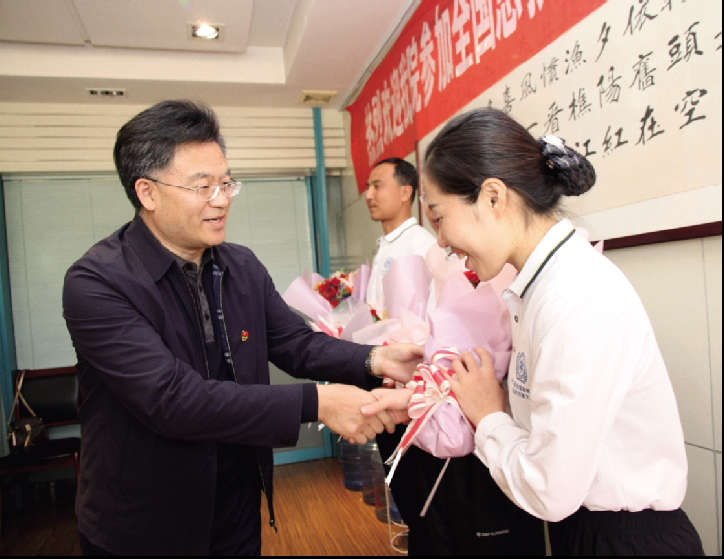 党委书记、理事长吕杰向载誉归来的同志们献花